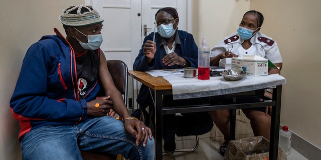 Medical staff talk to a man about to be vaccinated against COVID-19 at the Hillbrow Clinic in Johannesburg, South Africa, Monday Dec. 6, 2021. 