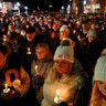 People gather for a candle light vigil for the victims of the Oxford High School shooting in downtown in Oxford, Michigan on December 3, 2021. - The parents of a 15-year-old boy who shot dead four students at a high school in the US state of Michigan with a gun bought for him by his father just days earlier were charged with involuntary manslaughter.