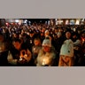 People gather for a candle light vigil for the victims of the Oxford High School shooting in downtown in Oxford, Michigan on December 3, 2021. - The parents of a 15-year-old boy who shot dead four students at a high school in the US state of Michigan with a gun bought for him by his father just days earlier were charged with involuntary manslaughter.