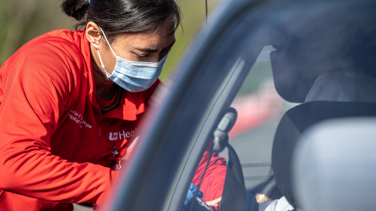 A medical professional from UofL Health administers a vaccine to a patient in their vehicle at University of Louisville Cardinal Stadium on April 12, 2021 in Louisville, Kentucky.  (Photo by Jon Cherry/Getty Images)