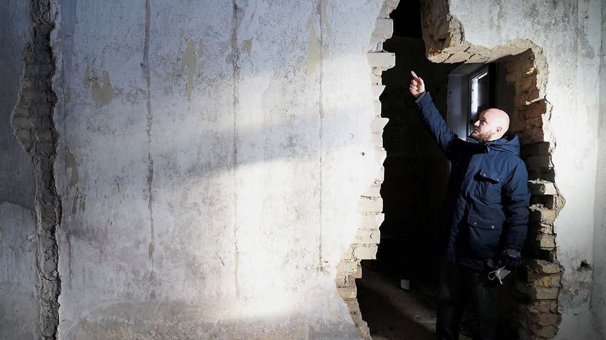 Building owner Jurgis Vilutis shows a hole in the wall where the letters were found in the former post office building in Vilnius, Lithuania.?