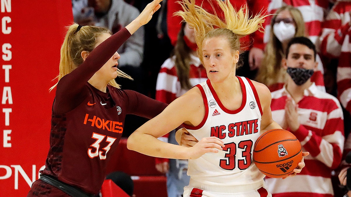 Virginia Tech's Elizabeth Kitle , left, battles with North Carolina State's Elissa Cunane, right, during the first half of an NCAA college basketball game, Sunday, Jan. 23, 2022, in Raleigh, N.C.