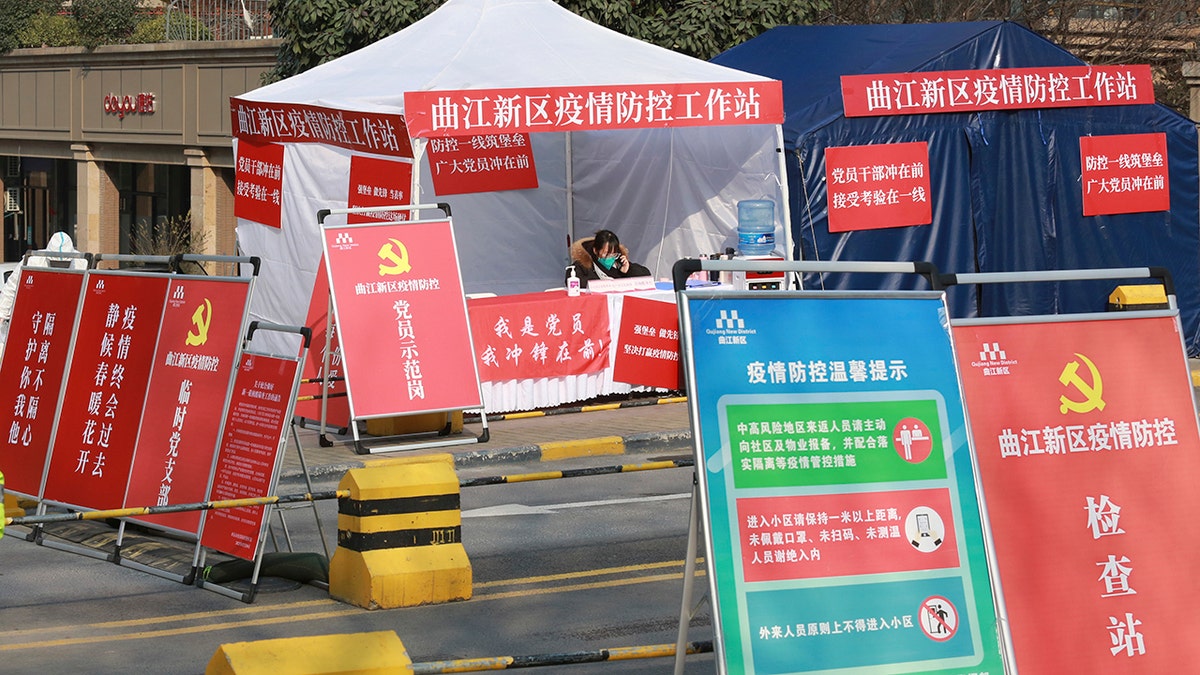 A government worker mans a pandemic checkpoint outside a residential block in Xi'an city in northwest China's Shaanxi province Monday, Jan. 3, 2022. (Chinatopix Via AP)