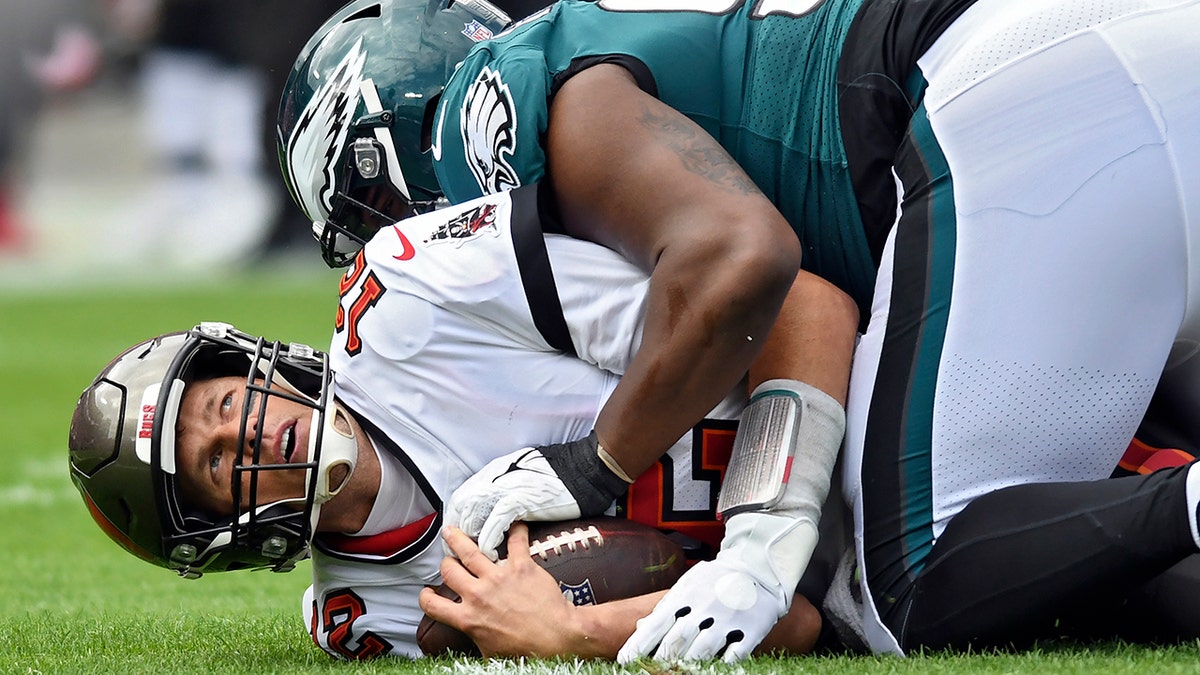Tampa Bay Buccaneers quarterback Tom Brady (12) gets sacked by Philadelphia Eagles defensive tackle Javon Hargrave during the first half of an NFL wild-card football game Sunday, Jan. 16, 2022, in Tampa, Fla.