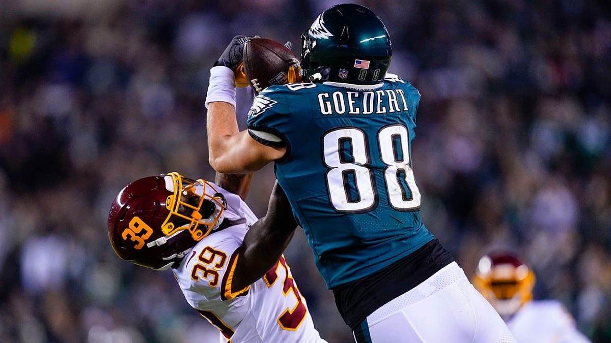 Philadelphia Eagles' Dallas Goedert, right, makes a catch while Washington Football Team's Jeremy Reaves defends during the first half of an NFL football game, Tuesday, Dec. 21, 2021, in Philadelphia.