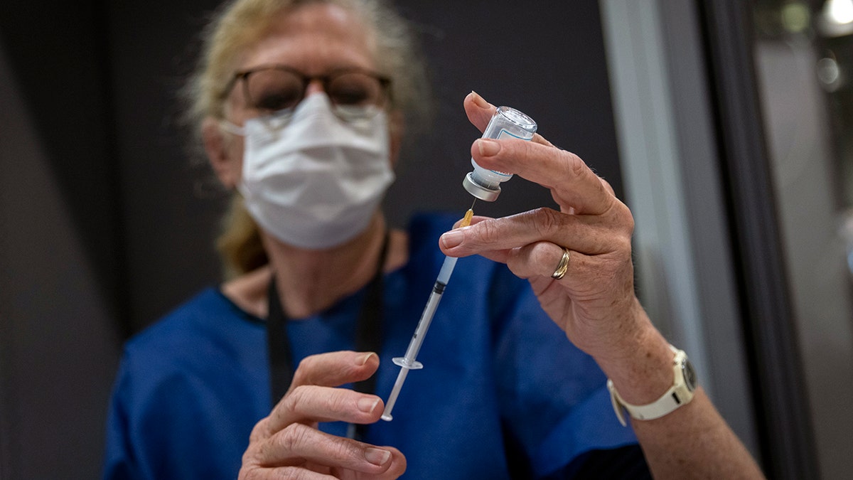 A medical worker prepares a shot of Moderna's COVID-19 vaccine, in a vaccination center, in Nantes, western France, Thursday, Dec. 30, 2021. (AP Photo/Jeremias Gonzales)