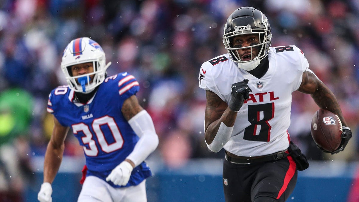 Atlanta Falcon Kyle Pitts (8) runs away from Buffalo Bill Dane Jackson (30) during the first half of a game Sunday, Jan. 2, 2022, in Orchard Park, N.Y.