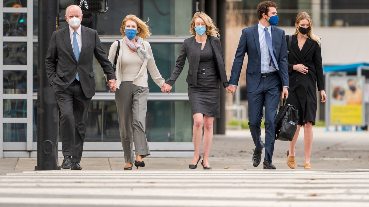 Elizabeth Holmes, center, walks to federal court in San Jose, Calif., Monday, Jan. 3, 2022. (AP Photo/Nic Coury)