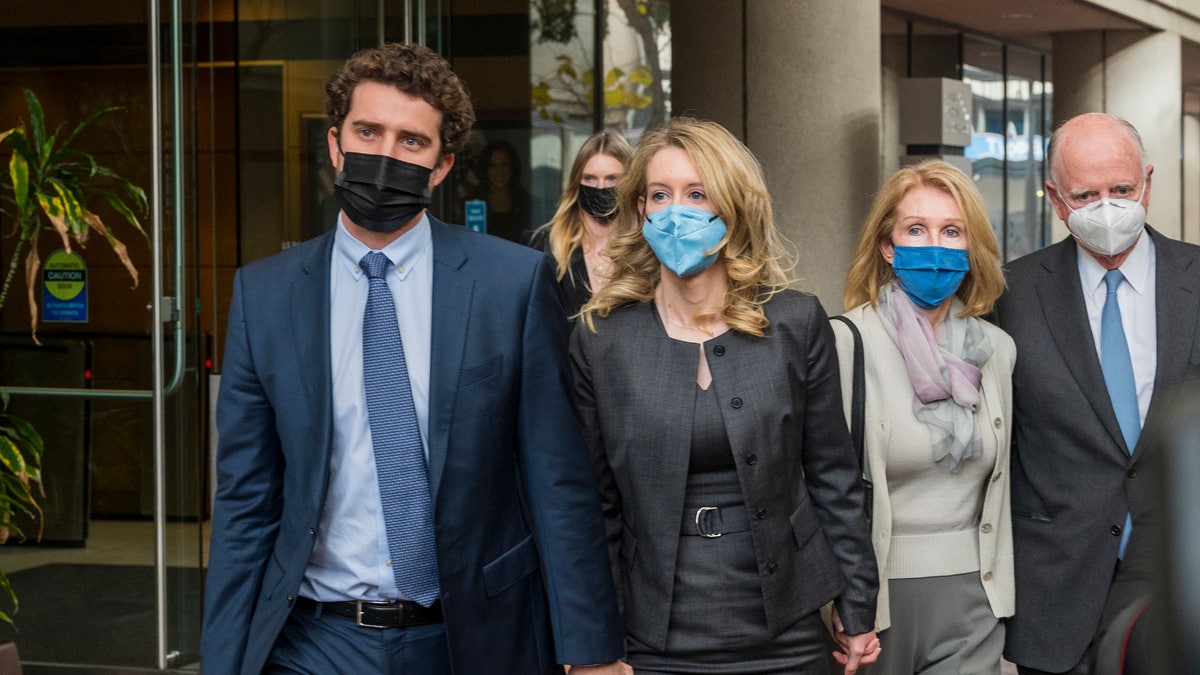 Elizabeth Holmes, center, leaves federal court in San Jose, Calif., Monday, Jan. 3, 2022. (AP Photo/Nic Coury)