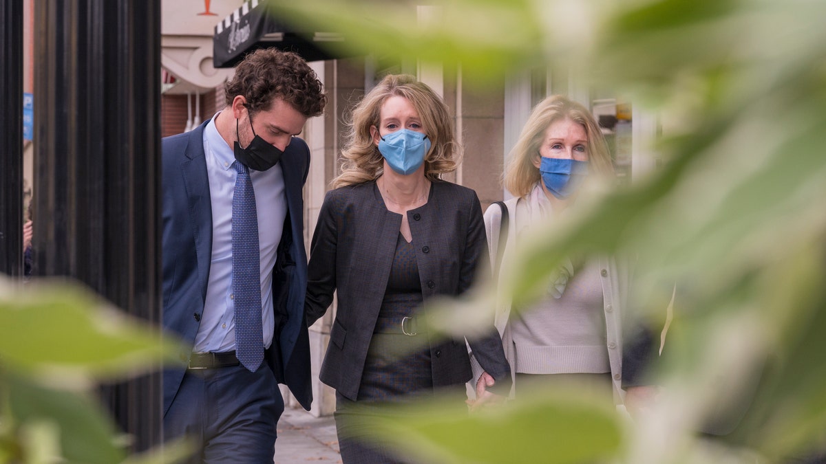 Elizabeth Holmes, center, leaves federal court in San Jose, Calif., Monday, Jan. 3, 2022. The jury weighing fraud charges against the former Theranos CEO on Monday informed the judge they are deadlocked on three of the 11 counts she faces.(AP Photo/Nic Coury)