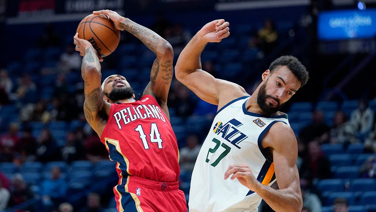 New Orleans Pelicans forward Brandon Ingram (14) shoots against Utah Jazz center Rudy Gobert (27) in the first half of an NBA basketball game in New Orleans, Monday, Jan. 3, 2022.
