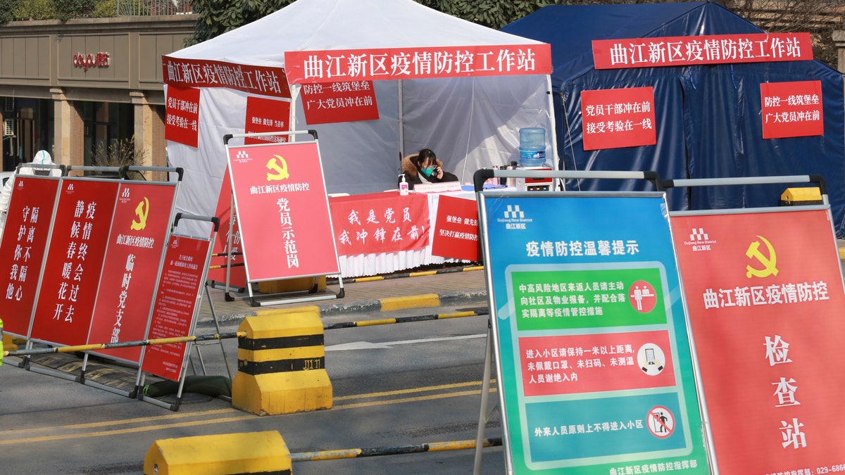 A government worker mans a pandemic checkpoint outside a residential block in Xi'an city in northwest China's Shaanxi province Monday, Jan. 3, 2022. (Chinatopix Via AP)