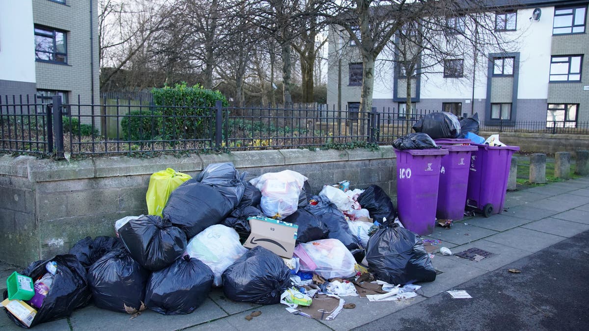 Overflowing bins await collection by refuse workers after coronavirus related staff shortages, in the Walton area of Liverpool, England, Tuesday, Jan. 4 2021. (Peter Byrne/PA via AP)
