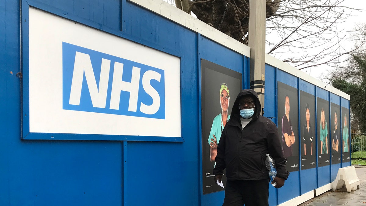 A pedestrian passes a COVID testing facility that has been set up at St.George's Hospital in London, Tuesday, Jan. 4, 2022. The NHS is expected to come under increasing pressure over the next few weeks from the Omicrom virus variant. (AP Photo/Kirsty Wigglesworth)