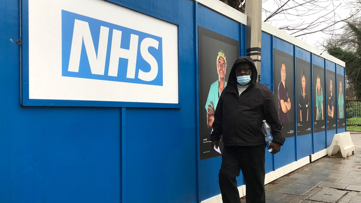 A pedestrian passes a COVID testing facility that has been set up at St.George's Hospital in London, Tuesday, Jan. 4, 2022. The NHS is expected to come under increasing pressure over the next few weeks from the Omicrom virus variant. (AP Photo/Kirsty Wigglesworth)