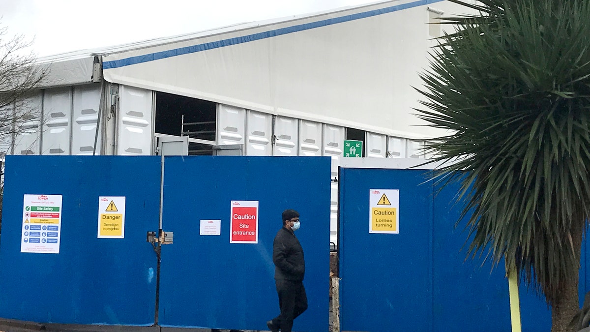 A pedestrian passes a COVID testing facility that has been set up at St.George's Hospital in London, Tuesday, Jan. 4, 2022. The NHS is expected to come under increasing pressure over the next few weeks from the Omicrom virus variant. (AP Photo/Kirsty Wigglesworth)