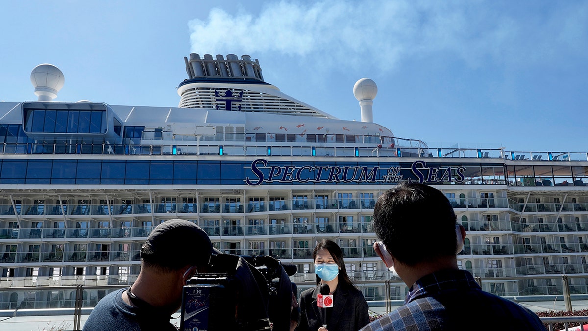 Journalists film the Spectrum of the Seas cruise ship which is docked at Kai Tak cruise terminal in Hong Kong Wednesday, Jan. 5, 2022. (AP Photo/Vincent Yu)