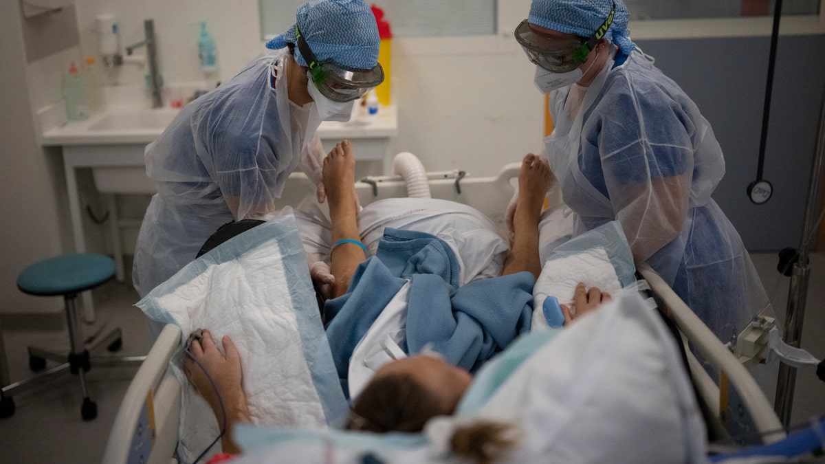 Nurses care for a patient with COVID-19 in the intensive care unit at the la Timone hospital in Marseille, southern France, Dec. 31, 2021. (AP Photo/Daniel Cole, File)