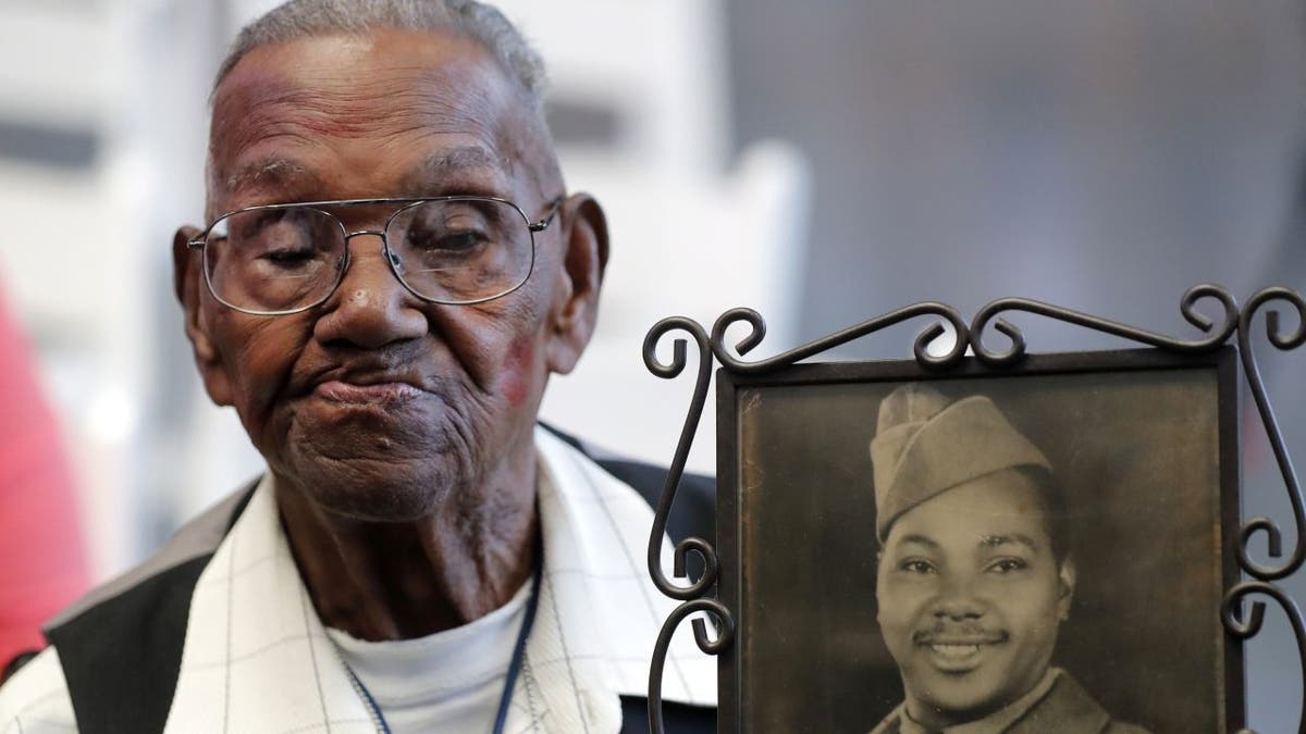 World War II veteran Lawrence Brooks died on Wednesday, Jan. 5, 2022, at the age of 112. In this file photo from Sept. 12, 2019 — his 110th birthday, Brooks holds a photo of himself, which was taken in 1943.