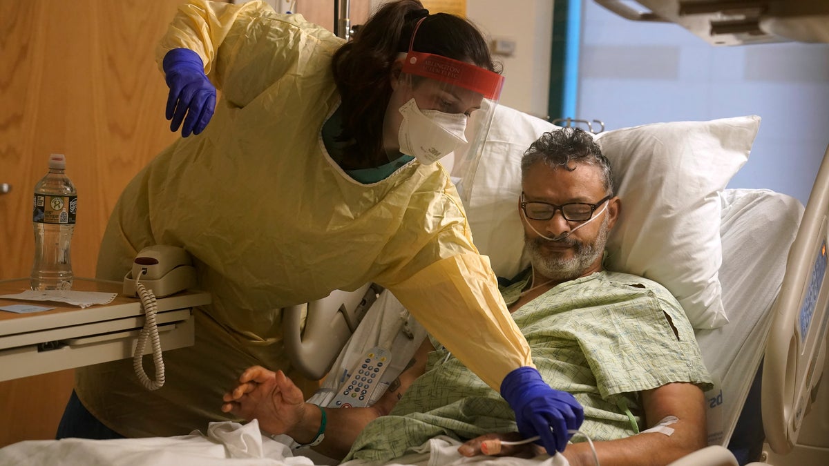 Register nurse Rachel Chamberlin, of Cornish, N.H., left, assists COVID-19 patient Fred Rutherford, of Claremont, N.H. (AP Photo/Steven Senne)