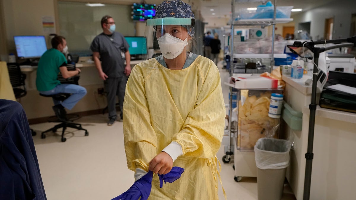 Registered Nurse Morgan Flynn prepares to enter a patient's room in the COVID-19 Intensive Care Unit at Dartmouth-Hitchcock Medical Center, in Lebanon, N.H. (AP Photo/Steven Senne)