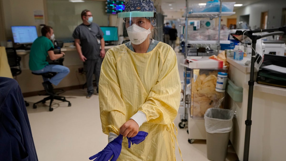 Registered Nurse Morgan Flynn prepares to enter a patient's room in the COVID-19 Intensive Care Unit at Dartmouth-Hitchcock Medical Center, in Lebanon, N.H. (AP Photo/Steven Senne)