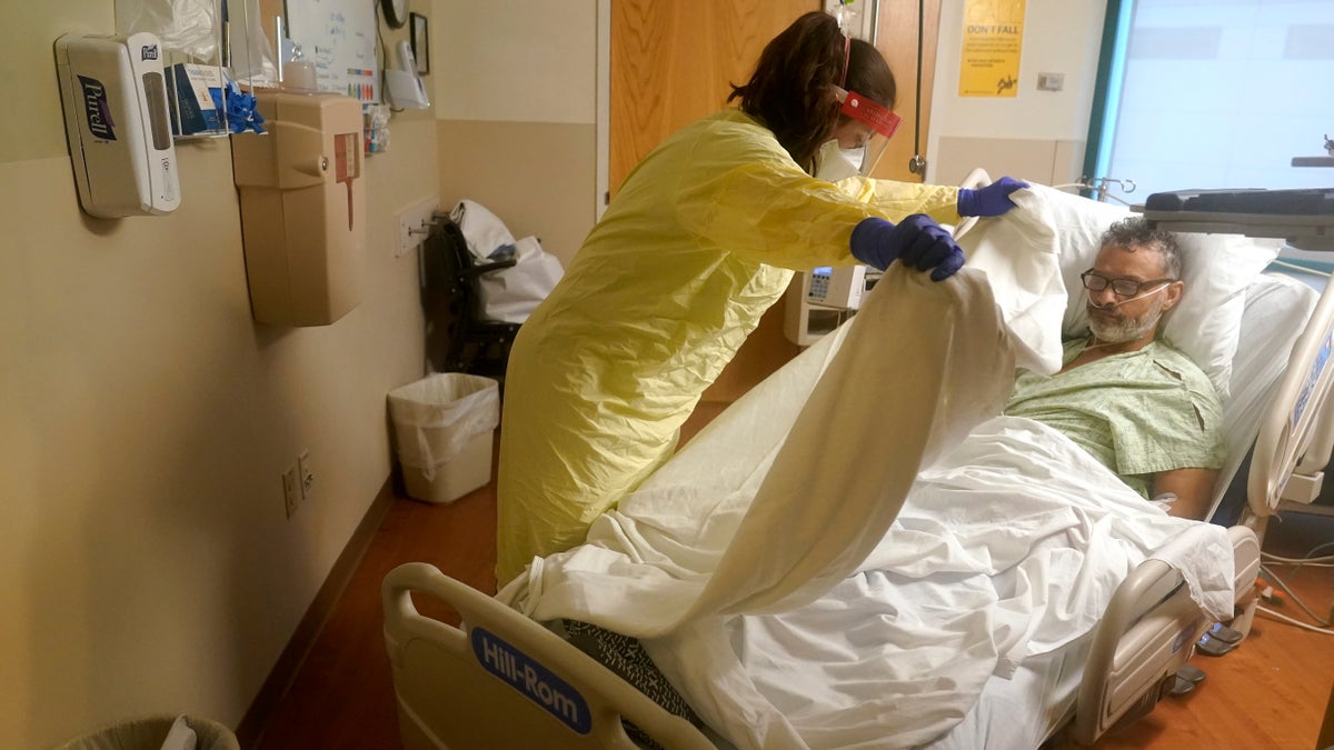 Registered nurse Rachel Chamberlin, of Cornish, N.H., left, tends to COVID-19 patient Fred Rutherford, of Claremont, N.H. (AP Photo/Steven Senne)
