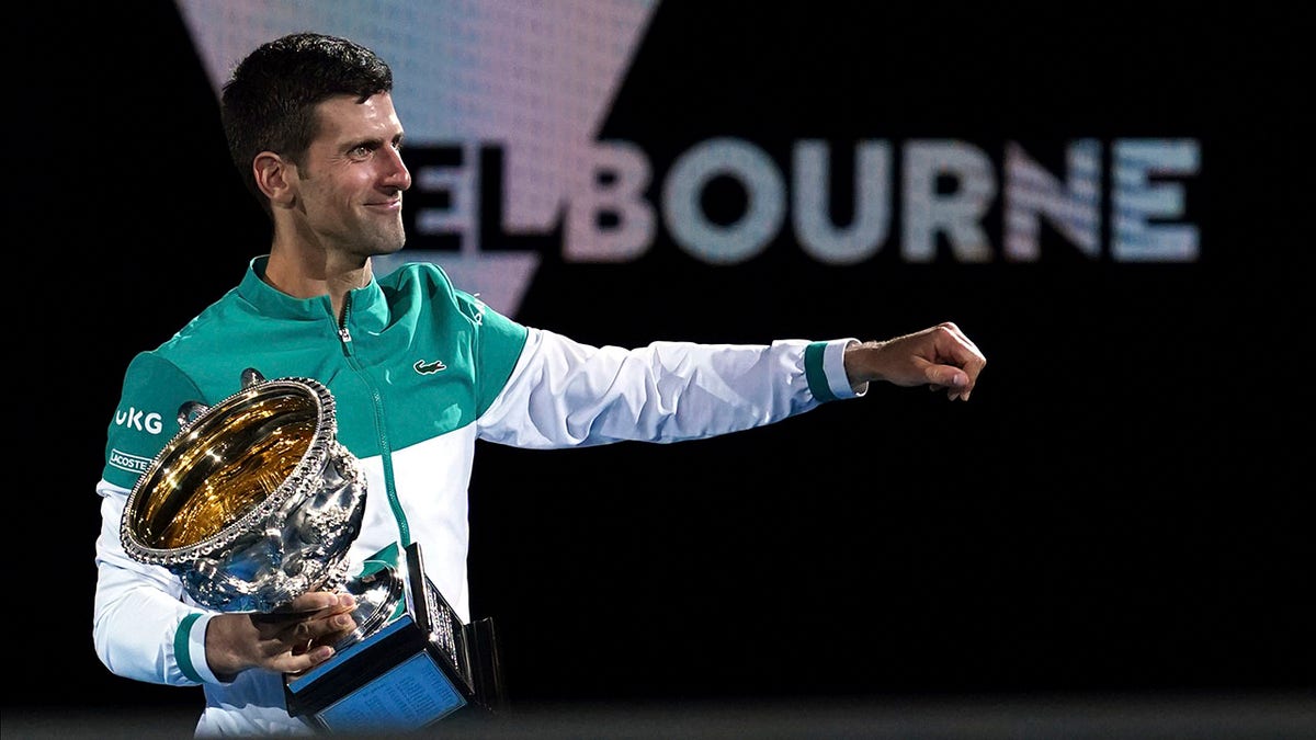 Serbia's Novak Djokovic holds the Norman Brookes Challenge Cup after defeating Russia's Daniil Medvedev in the men's singles final at the Australian Open tennis championship in Melbourne, Australia, Sunday, Feb. 21, 2021. 