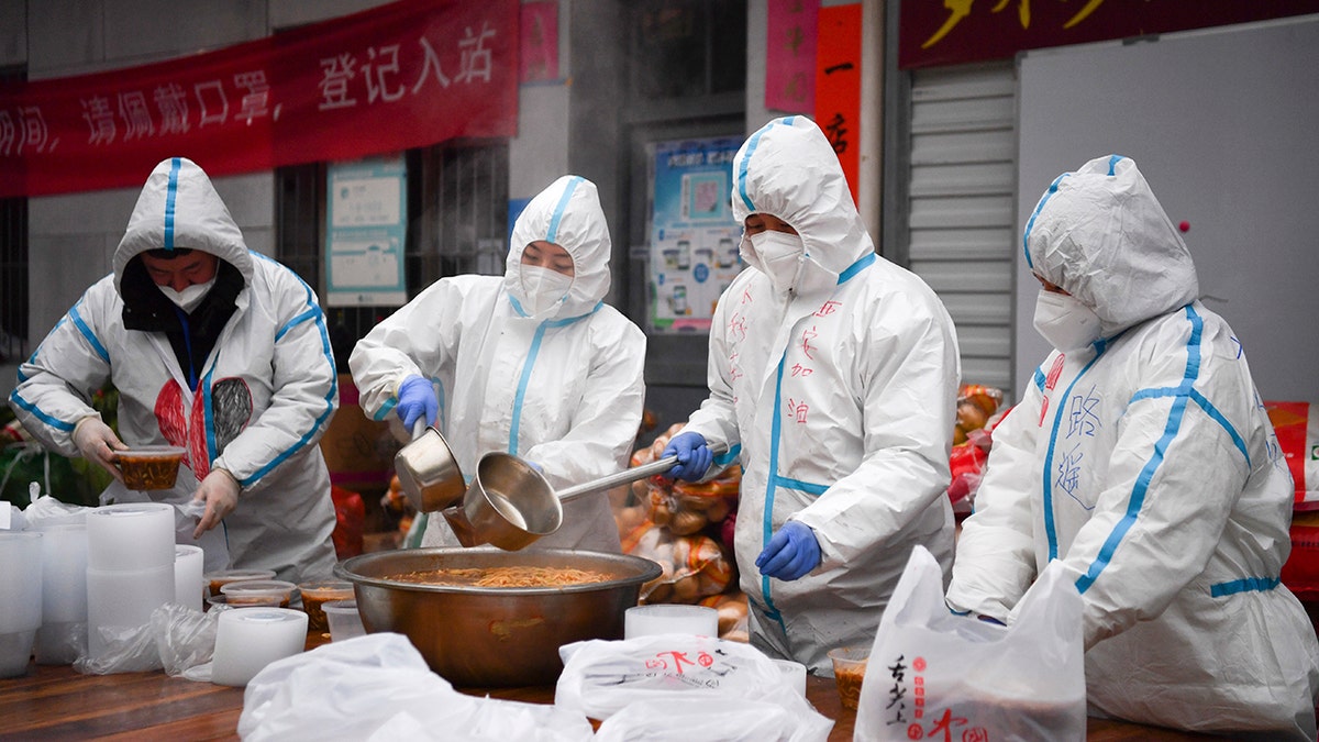 In this photo released by China's Xinhua News Agency, volunteers wearing protective suits package meals for delivery to people under lockdown in Xi'an in northwestern China's Shaanxi Province, Tuesday, Jan. 4, 2022. (Zhang Bowen/Xinhua via AP)
