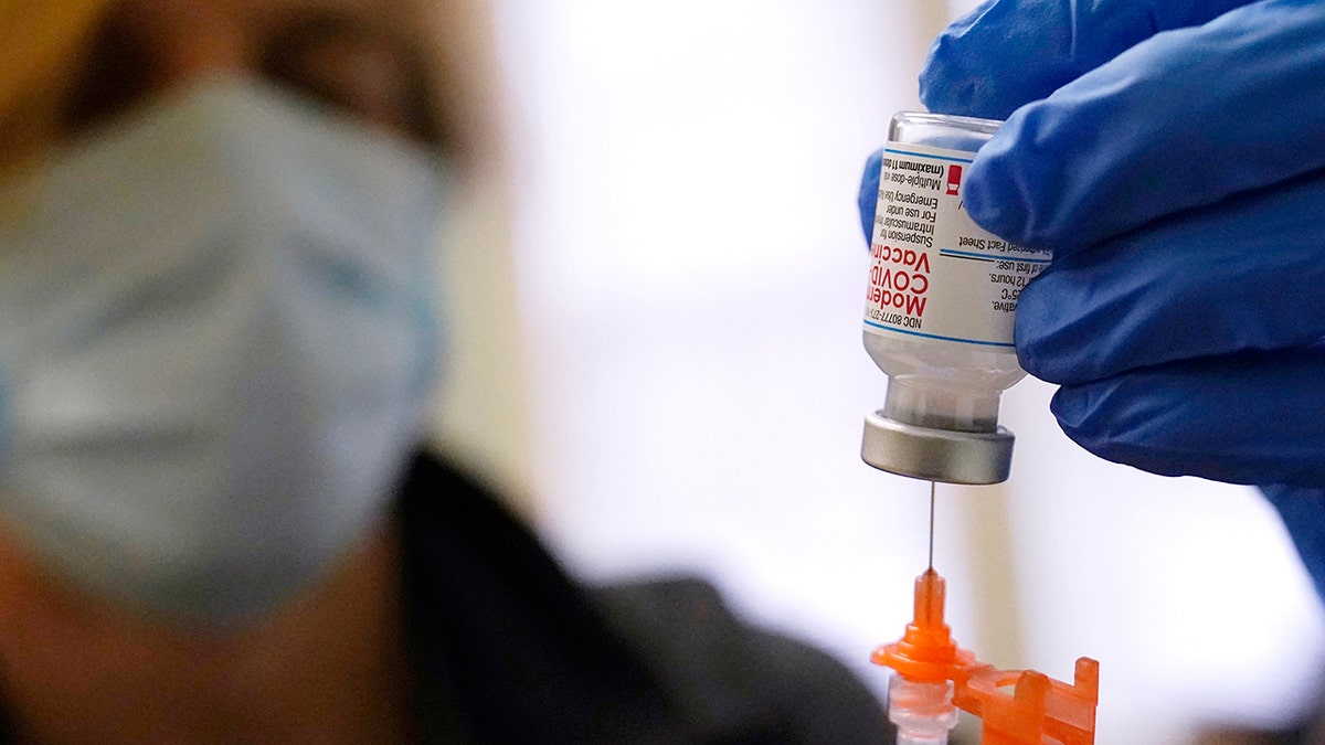 Pharmacist Kenni Clark prepares a booster dose of the Moderna COVID-19 vaccine during a vaccination clinic Dec. 29, 2021, in Lawrence, Massachusetts.