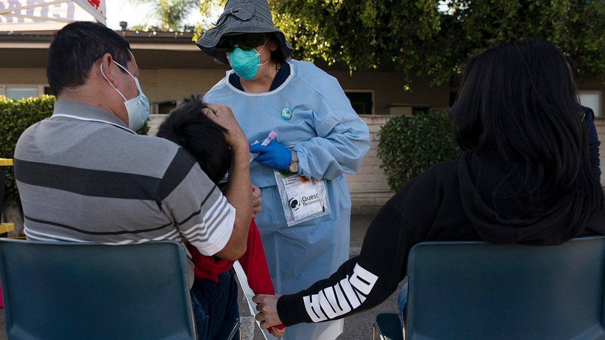 Nurse practitioner Rita Ray collects a nasal swab sample from Sebastian Hernandez, 5, for a COVID-19 test at Families Together of Orange County community health center in Tustin, California, Jan. 6, 2022.