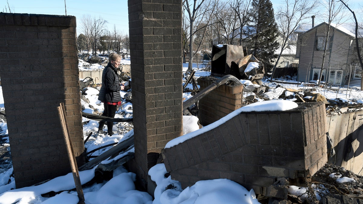 Barba Hickman surveys the rubble of her burned home in Louisville, Colo., on Jan. 2, 2022. (AP Photo/Thomas Peipert, File)