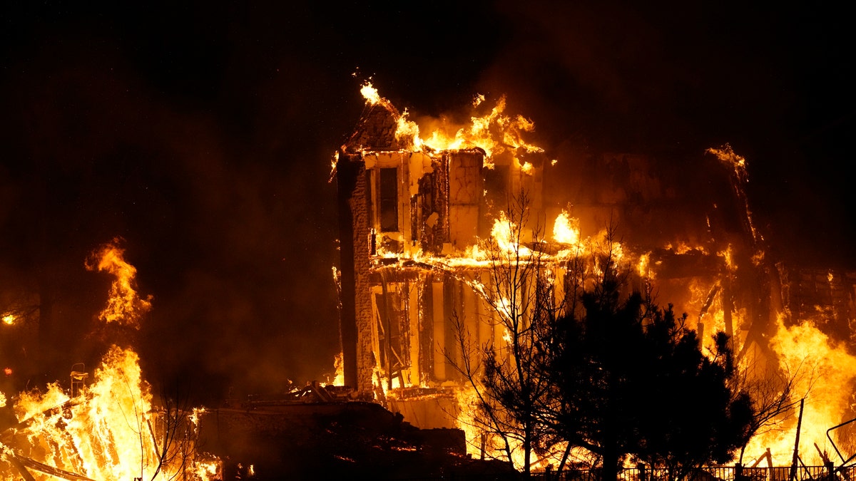Homes burn as a wildfire rips through a development near Rock Creek Village, Dec. 30, 2021, near Broomfield, Colo. (AP Photo/David Zalubowski, File)