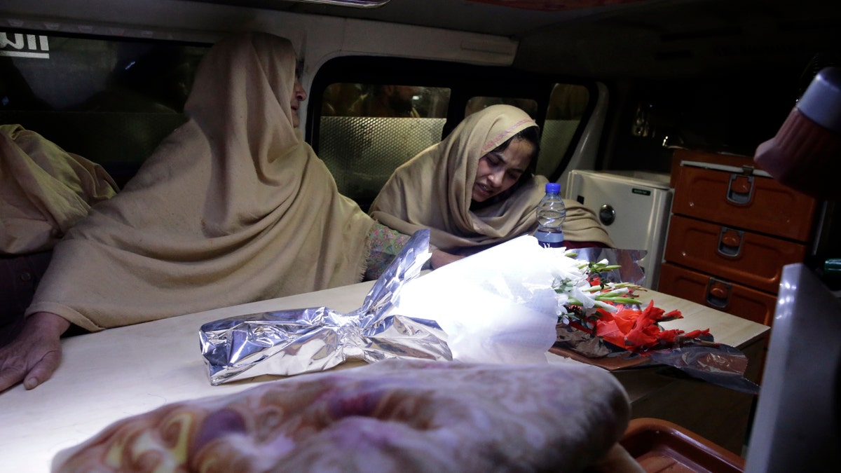 Women cry inside an ambulance after they lost their family members during a heavy snowfall-hit area in Murree, some 28 miles (45 kilometers) north of the capital of Islamabad, Pakistan, Saturday, Jan. 8, 2022. (AP Photo/Rahmat Gul)