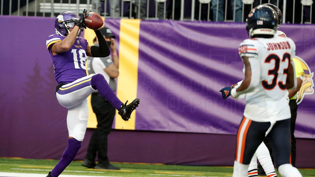 Minnesota Vikings wide receiver Justin Jefferson (18) catches a 45-yard touchdown pass ahead of Chicago Bears cornerback Jaylon Johnson (33) during the second half of an NFL football game, Sunday, Jan. 9, 2022, in Minneapolis.