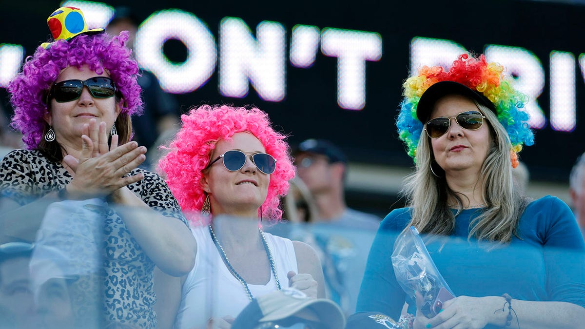 Fans dressed as clowns watch during the first half of an NFL football game between the Jacksonville Jaguars and the Indianapolis Colts, Sunday, Jan. 9, 2022, in Jacksonville, Fla.