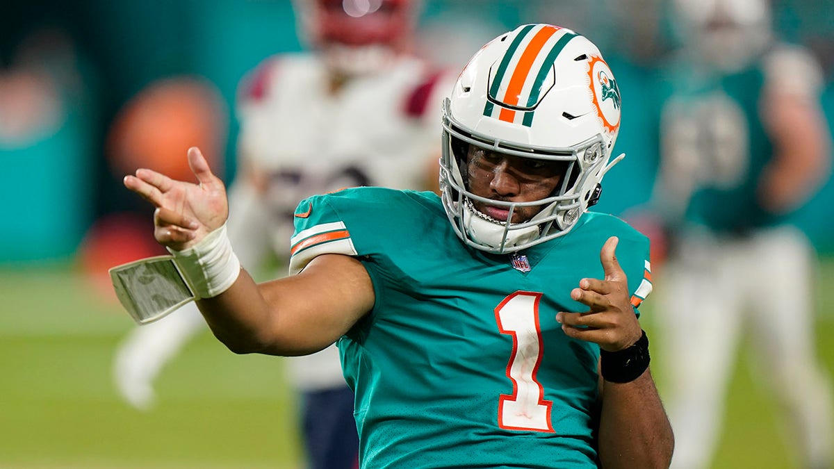 Miami Dolphins quarterback Tua Tagovailoa celebrates after running to gain yardage during the second half of an NFL football game against the New England Patriots, Sunday, Jan. 9, 2022, in Miami Gardens, Florida.