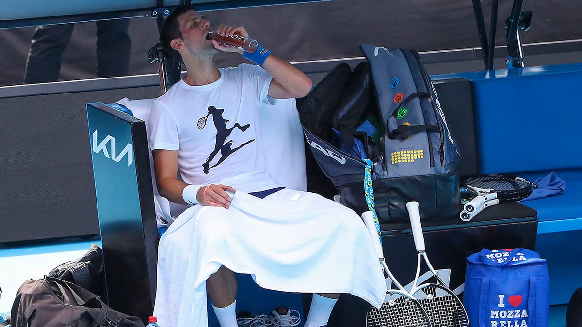 Defending champion Serbia's Novak Djokovic takes a drink during a practice session at the Rod Laver Arena ahead of the Australian Open at Melbourne Park in Melbourne, Australia, Tuesday, Jan. 11, 2022.