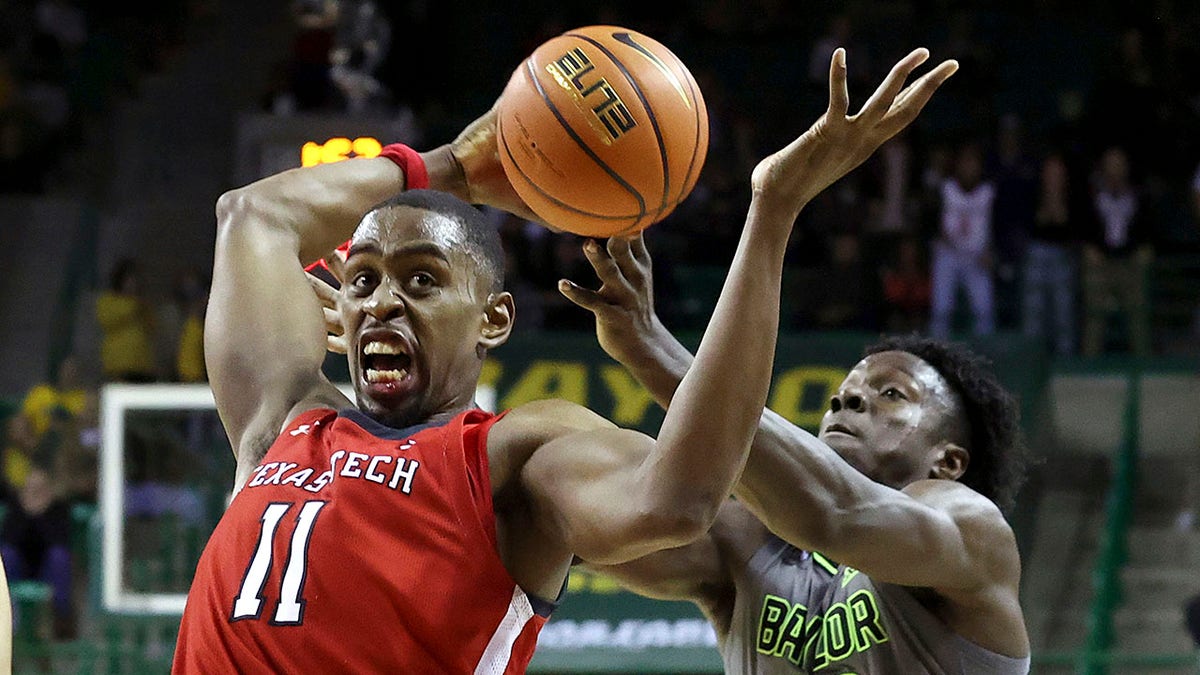 CORRECTS ID TO BAYLOR FORWARD JONATHAN TCHAMWA TCHATCHOUA, RIGHT - Texas Tech forward Bryson Williams, left,,  grabs a loose ball from Baylor forward Jonathan Tchamwa Tchatchoua during the second half of an NCAA college basketball game Tuesday, Jan. 11, 2022, in Waco, Texas.