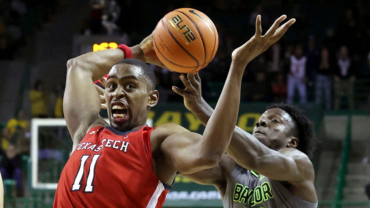 CORRECTS ID TO BAYLOR FORWARD JONATHAN TCHAMWA TCHATCHOUA, RIGHT - Texas Tech forward Bryson Williams, left,, grabs a loose ball from Baylor forward Jonathan Tchamwa Tchatchoua during the second half of an NCAA college basketball game Tuesday, Jan. 11, 2022, in Waco, Texas.