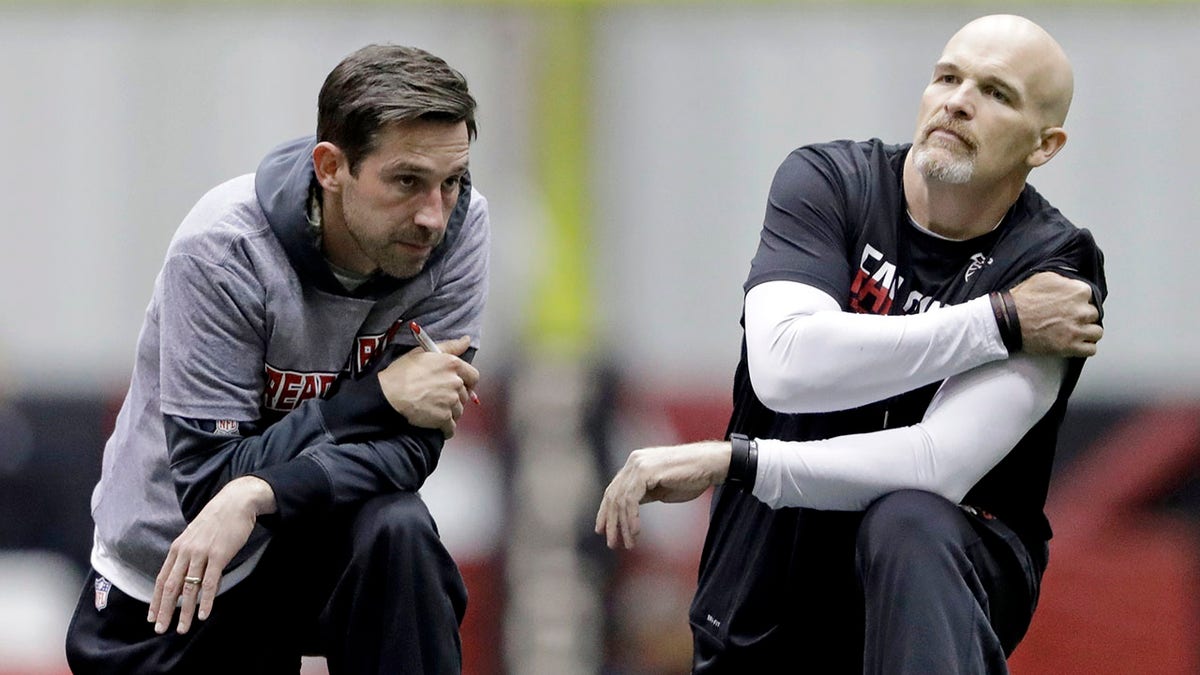 FILE - Atlanta Falcons head coach Dan Quinn, right, talks with offensive coordinator Kyle Shanahan during a workout at the NFL football team's practice facility in Flowery Branch, Ga., Friday, Jan. 27, 2017. Kyle Shanahan and Dan Quinn will always share the painful memory of coaching in the Super Bowl together with Atlanta five years ago when the Falcons couldn't hold a 25-point lead in the second half of a loss to New England. The wild-card meeting Sunday, Jan. 16, 2022 between the visiting 49ers (10-7) and Cowboys (12-5) is the first in the playoffs involving both coaches since that crushing loss in Houston.