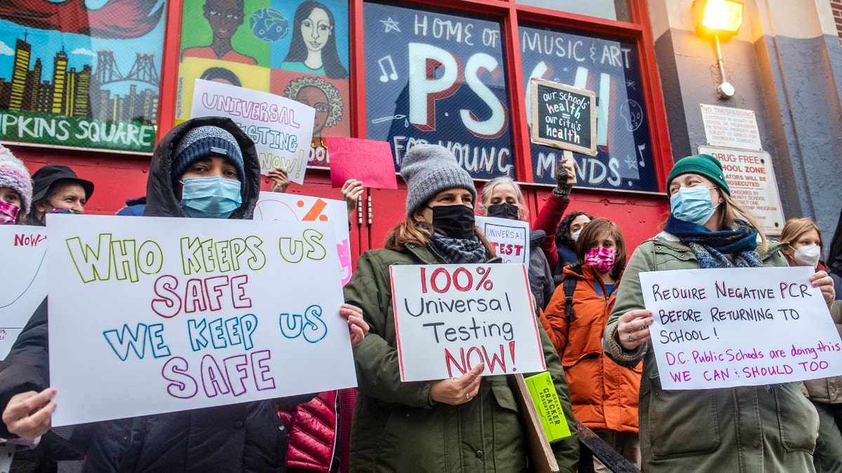 Teachers from the Earth School speak out on issues related to lack of COVID testing outside P.S. 64, Dec. 21, 2021, in New York. In a reversal, New York Mayor Eric Adams is considering a remote option for schools. (AP Photo/Brittainy Newman, File)