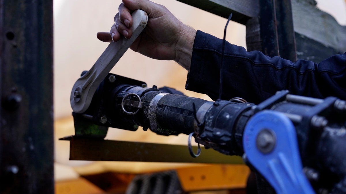 A Georgia Department of Transportation response member pulls a lever on a brine truck ahead of a winter storm at the GDOT's Maintenance Activities Unit location on Friday, Jan. 14, 2022, in Forest Park, Ga. (AP Photo/Brynn Anderson)