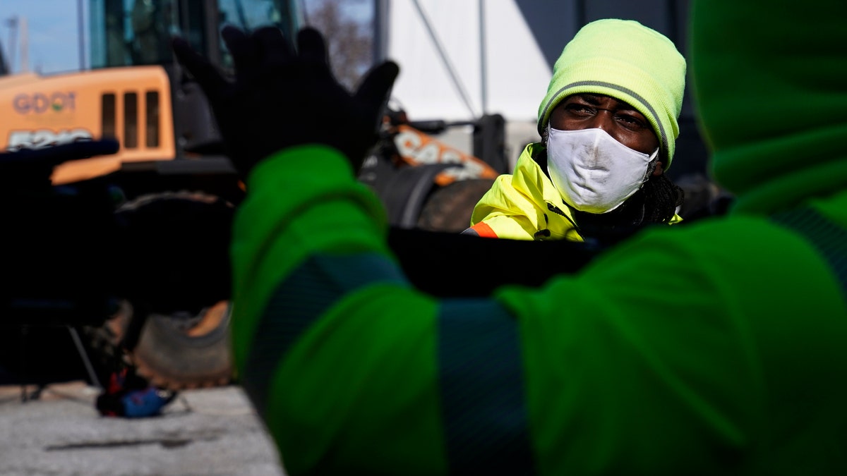 A Georgia Department of Transportation response member looks at a brine truck tank being filled ahead of a winter storm at the GDOT's Maintenance Activities Unit location on Friday, Jan. 14, 2022, in Forest Park, Ga. (AP Photo/Brynn Anderson)