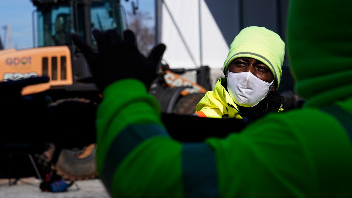 A Georgia Department of Transportation response member looks at a brine truck tank being filled ahead of a winter storm at the GDOT's Maintenance Activities Unit location on Friday, Jan. 14, 2022, in Forest Park, Ga. (AP Photo/Brynn Anderson)