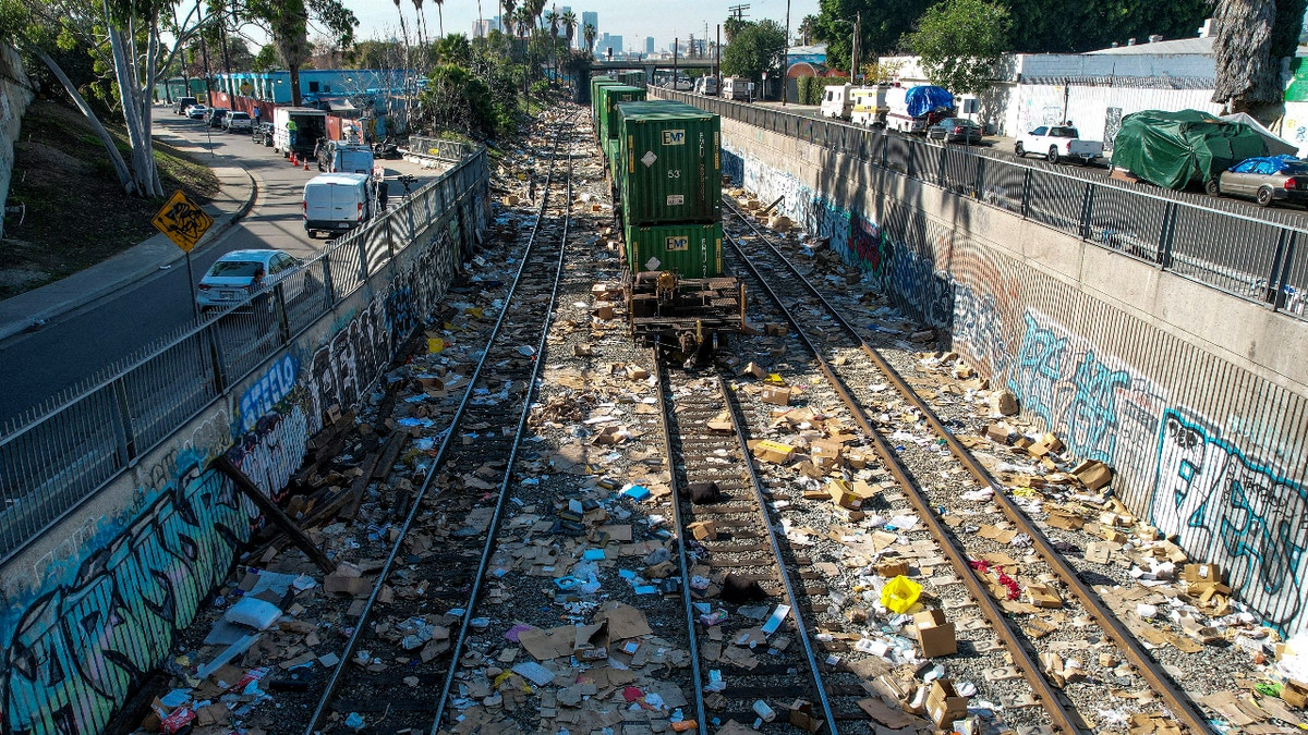 A train stops as shredded boxes and packages are seen at a section of the Union Pacific train tracks in downtown Los Angeles Friday, Jan. 14, 2022. (AP Photo/Ringo H.W. Chiu)