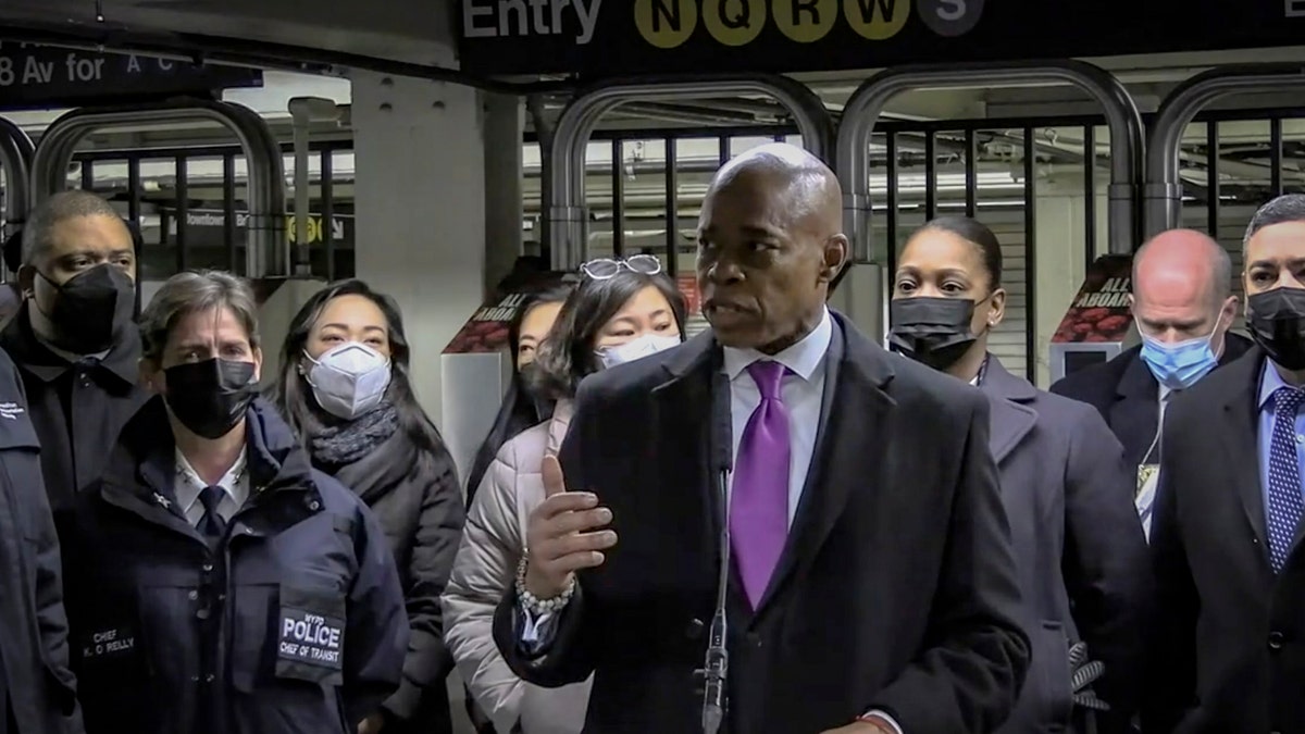 In this livestream frame grab from video provided by NYPD News, Mayor Eric Adams, foreground, with city law officials, speaks at a news conference inside a subway station after a woman was pushed to her death in front of a subway train at the Times Square station, Saturday, Jan. 15, 2022, in New York. (NYPD News via AP)