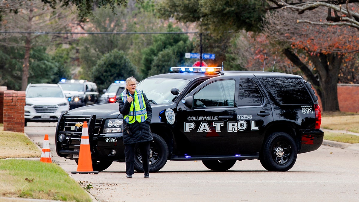 Law enforcement officials block a residential street near Congregation Beth Israel synagogue where a man took hostages during services on Saturday, Jan. 15, 2022, in Colleyville, Texas.