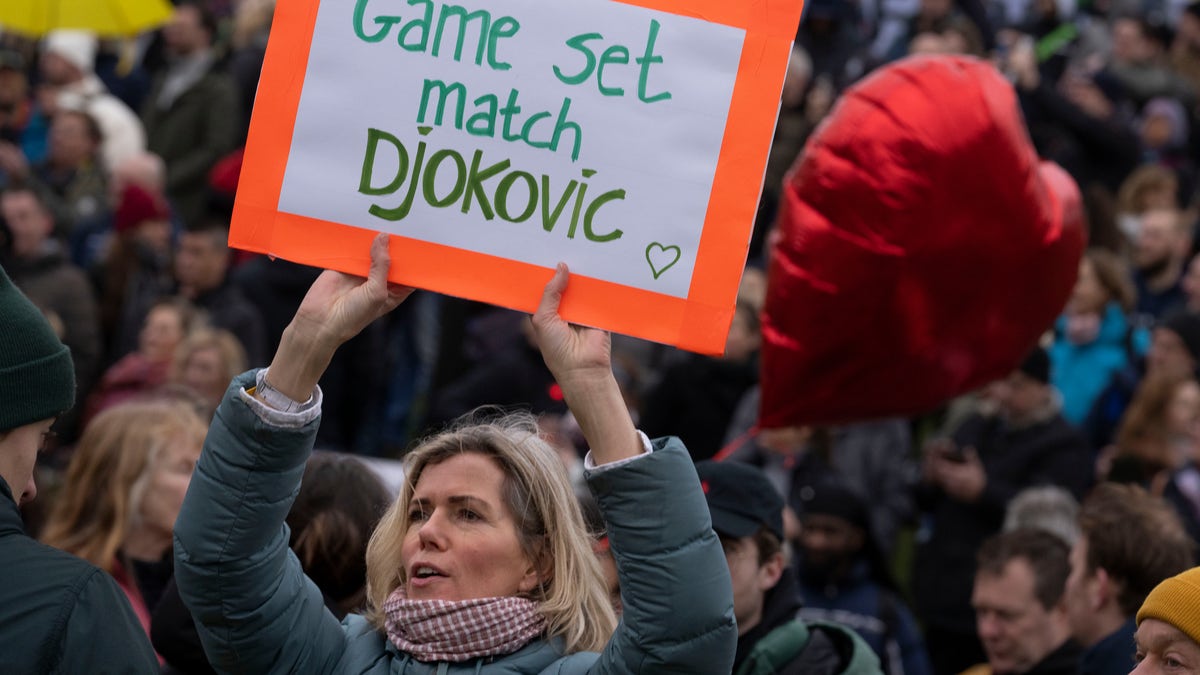 A woman holds a message for Serbia's Novak Djokovic a