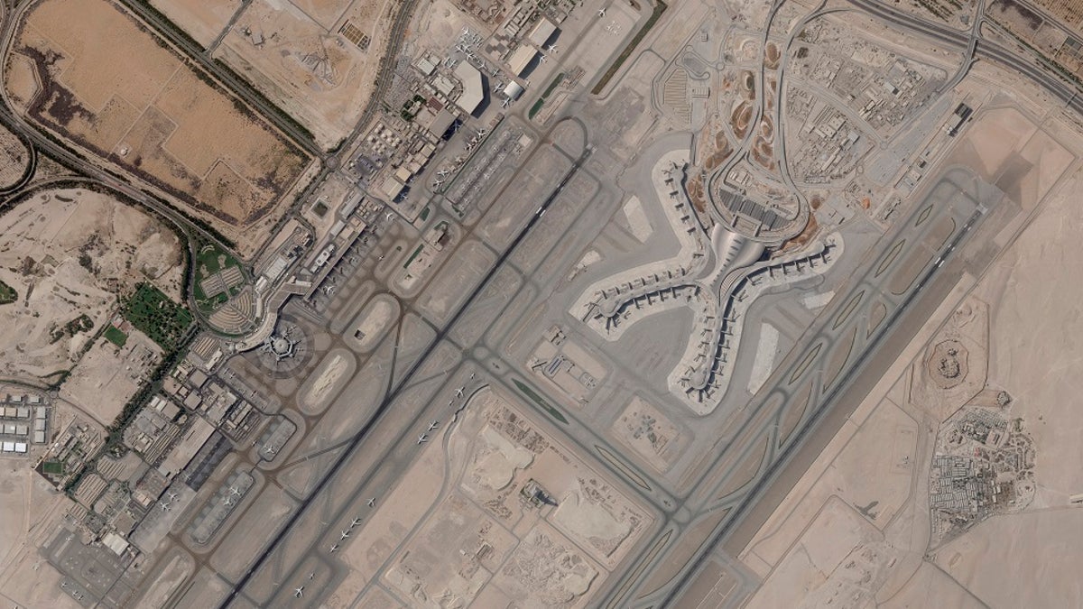 In a satellite photo by Planet Labs PBC, Abu Dhabi International Airport is seen Dec. 8, 2021. A suspected drone attack by Yemen's Houthi rebels targeting a key oil facility in Abu Dhabi killed three people and sparked a separate fire at Abu Dhabi's international airport on Monday, Jan. 17, 2022, police said. (Planet Labs PBC via AP)